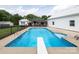 Beautiful in-ground pool with diving board, concrete surround, ladder, and open to the covered deck at 2054 Hickory Hills Dr, Denver, NC 28037