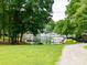 Picturesque waterfront view with a grassy lawn and mature trees overlooking boats docked on the calm water at 2054 Hickory Hills Dr, Denver, NC 28037
