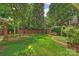 Spacious backyard with lush lawn, mature trees, brick wall, and manicured landscaping at 2126 Norton Rd, Charlotte, NC 28207