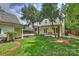 Expansive backyard featuring lush green grass, mature trees and a cozy patio area at 2126 Norton Rd, Charlotte, NC 28207