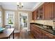 Charming dining area boasts hardwood floors, a built-in bar with black countertops and vintage cabinets at 2126 Norton Rd, Charlotte, NC 28207