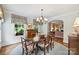 Sunlit dining room with a round rug under a wood table set for six people, adjacent to the living room at 2126 Norton Rd, Charlotte, NC 28207