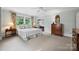 Bright main bedroom boasts natural light from large windows, neutral walls and carpet, and furniture at 2126 Norton Rd, Charlotte, NC 28207