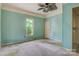 Bright bedroom featuring blue walls, carpeted floor, a window, and a ceiling fan at 252 7Th Se St, Hickory, NC 28602