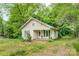 Quaint single-story home with a front porch, surrounded by mature trees and greenery at 252 7Th Se St, Hickory, NC 28602