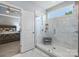 Bathroom with a large glass shower featuring marble tiles, a shower bench, and an attached bedroom at 2625 Rea Pond Ct, Charlotte, NC 28226