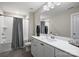 Bathroom features a shower-tub combination, gray shower curtain, and white vanity with a dark vase at 2625 Rea Pond Ct, Charlotte, NC 28226