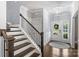 Light-filled foyer featuring hardwood floors, staircase, and a glimpse of the exterior through the front door at 2625 Rea Pond Ct, Charlotte, NC 28226