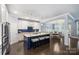 Bright, open kitchen with white cabinets, stainless appliances, center island with seating, and adjacent dining space at 2625 Rea Pond Ct, Charlotte, NC 28226