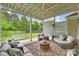 Covered outdoor patio featuring a ceiling fan, comfortable seating, and views of the fenced backyard at 2625 Rea Pond Ct, Charlotte, NC 28226