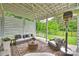 Covered patio has ceiling fan, outdoor heater, comfortable seating and a swing overlooking the green yard at 2625 Rea Pond Ct, Charlotte, NC 28226