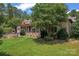 A lush landscaped backyard with an outdoor kitchen and covered porch at 277 Tradition Dr, Mount Gilead, NC 27306