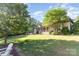 Lush backyard with mature trees, manicured lawn, and a view of the home's exterior at 277 Tradition Dr, Mount Gilead, NC 27306