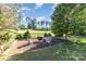Landscaped backyard featuring a fire pit, seating, and views of the golf course beyond at 277 Tradition Dr, Mount Gilead, NC 27306