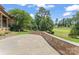 Backyard patio with stone wall, overlooking well manicured lawn and landscape at 277 Tradition Dr, Mount Gilead, NC 27306
