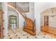 Elegant foyer featuring a curved wooden staircase with iron railings and marble floors with black accents at 277 Tradition Dr, Mount Gilead, NC 27306