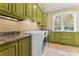 Convenient laundry room with a modern washer and dryer, marble countertops, a window, and olive-colored cabinets at 277 Tradition Dr, Mount Gilead, NC 27306