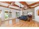 Bright living room featuring wood floors, ceiling beams, and double doors to the outside at 277 Tradition Dr, Mount Gilead, NC 27306