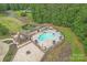 Aerial view of the community pool, lounge chairs with umbrellas, a fire pit, and a covered area at 277 Tradition Dr, Mount Gilead, NC 27306
