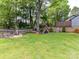 Expansive backyard featuring a playground, storage shed, and a charming fire pit area at 2804 Park Rd, Charlotte, NC 28209