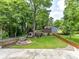 Expansive backyard features a fire pit, playset, mature trees, and well-maintained landscaping at 2804 Park Rd, Charlotte, NC 28209