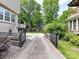 Long driveway leading to a backyard with lush trees, charming shed and a playground at 2804 Park Rd, Charlotte, NC 28209