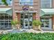The brick exterior of East Blvd Bar & Grill with green awnings, brick columns, and planted landscaping at 2804 Park Rd, Charlotte, NC 28209