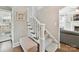 Elegant staircase featuring carpeted steps, a white banister, and a comfortable landing at 2804 Park Rd, Charlotte, NC 28209