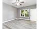 Bright bedroom featuring wood floors, a ceiling fan, and a window overlooking trees at 2817 Lakefront Dr, Belmont, NC 28012