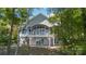 Two-story home features a wall of windows, deck with white railing, and stone fireplace feature at 2817 Lakefront Dr, Belmont, NC 28012