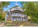 Multi-level home with stone accents and a balcony, nestled among trees, blending architecture with nature at 2817 Lakefront Dr, Belmont, NC 28012
