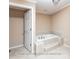 Bathroom with a step-up soaking tub and neutral tile flooring at 2818 Cherry Ln, Denver, NC 28037