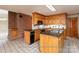Traditional kitchen with wooden cabinetry, a brick accent wall, and checkered tile flooring at 2818 Cherry Ln, Denver, NC 28037