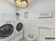 Bright laundry room with modern washer and dryer units, shelving, and decor at 4015 Pritchard Pl, Fort Mill, SC 29715