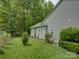 Backyard featuring well-maintained lawn and established green shrubs, with the home's gray siding at 433 Linsbury Ct, Gastonia, NC 28056