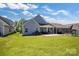 Large backyard with manicured lawn, patio, and a covered porch at 5112 Larewood Dr, Charlotte, NC 28215