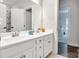 Clean bathroom featuring double sinks, white cabinets, and a view into a bedroom at 5112 Larewood Dr, Charlotte, NC 28215