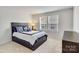 Comfortable bedroom featuring a dark wood bed frame with blue and white bedding and a window view at 5112 Larewood Dr, Charlotte, NC 28215
