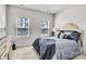 Bright bedroom with neutral carpet, two windows, and a stylish bed with decorative pillows at 5112 Larewood Dr, Charlotte, NC 28215