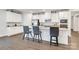 Bright kitchen featuring white cabinets, granite countertops, stainless steel appliances and three bar stools at 5112 Larewood Dr, Charlotte, NC 28215