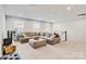 Bright living room with a large sectional sofa, neutral carpet, and staircase at 5112 Larewood Dr, Charlotte, NC 28215