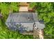 Aerial view of home with a dark roof, chimney, and a wood deck surrounded by trees at 540 Garrison Sw Ct, Concord, NC 28025
