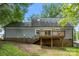 Back exterior of home with wooden deck, gray siding, and partial brick foundation at 540 Garrison Sw Ct, Concord, NC 28025