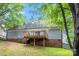 Back exterior of home with wooden deck, gray siding, and partial brick foundation at 540 Garrison Sw Ct, Concord, NC 28025
