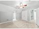 Spacious bedroom featuring neutral walls, a ceiling fan, closets, window, and carpeted floor at 540 Garrison Sw Ct, Concord, NC 28025