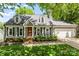 Charming home featuring a well-manicured front yard, gray siding, black shutters, and a red front door at 540 Garrison Sw Ct, Concord, NC 28025