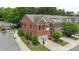 Aerial view of brick townhomes with two-car garages, landscaping, and street access at 5422 Shannon Bell Ln, Charlotte, NC 28277
