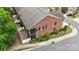 Aerial view of brick townhome featuring a backyard, mature trees, well kept lawn, and paved driveway at 5422 Shannon Bell Ln, Charlotte, NC 28277