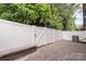 Private backyard featuring a paved patio, stone bench, well maintained fencing, and mature trees at 5422 Shannon Bell Ln, Charlotte, NC 28277