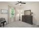 Comfortable bedroom features a ceiling fan, a large dresser, a window, and natural light at 5422 Shannon Bell Ln, Charlotte, NC 28277
